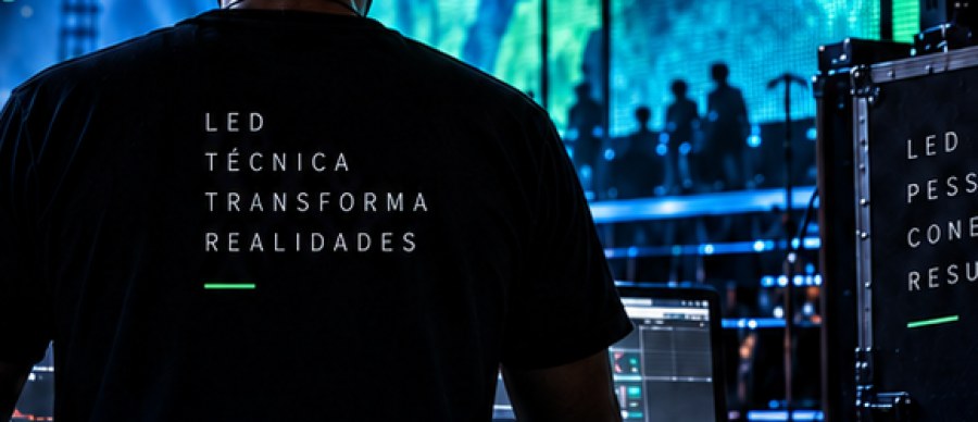 Operador no console durante evento, com painel de LED ao fundo